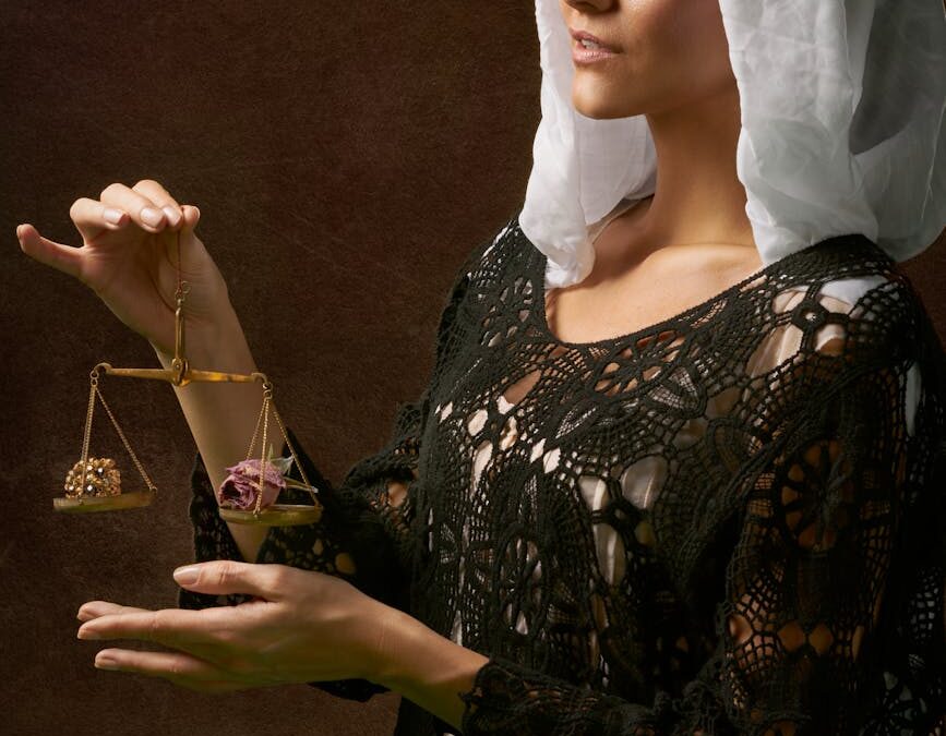 woman in black dress holding balance scale