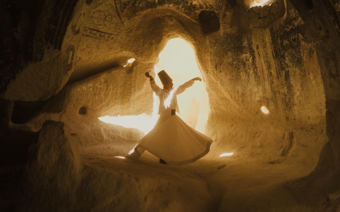 a woman in a white dress dancing in a cave